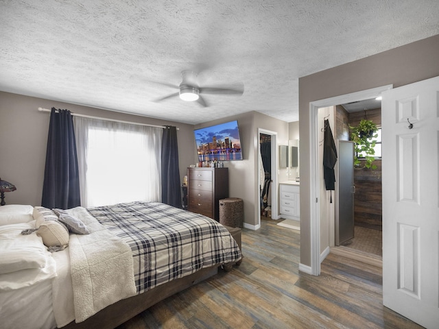 bedroom featuring ensuite bathroom, dark hardwood / wood-style floors, a textured ceiling, and ceiling fan