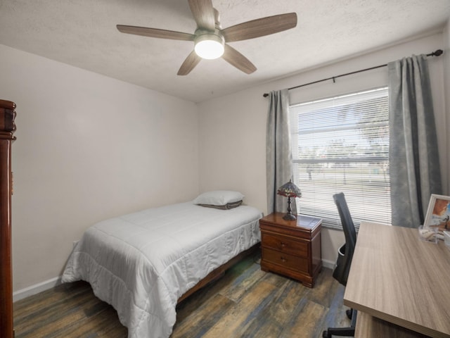 bedroom featuring ceiling fan, dark wood-type flooring, and a textured ceiling