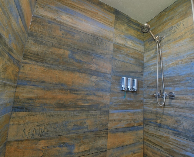 interior details with tiled shower and a textured ceiling