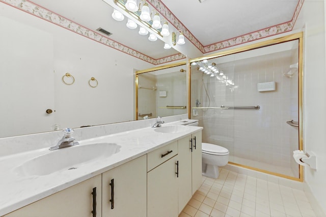 bathroom with tile patterned flooring, vanity, a shower with shower door, and toilet