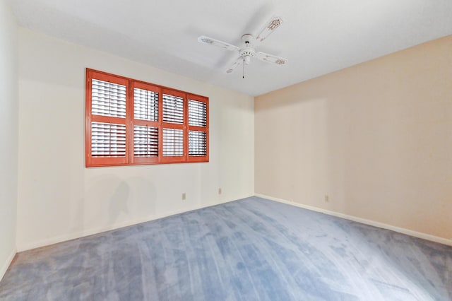 carpeted spare room with ceiling fan