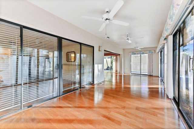 unfurnished sunroom featuring ceiling fan