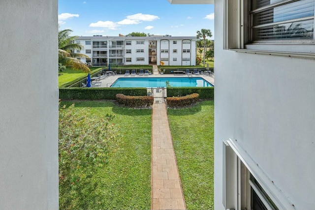 view of pool with a yard