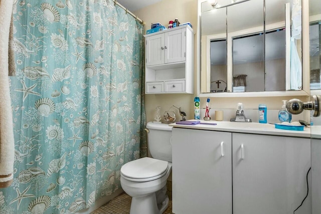 bathroom with toilet, vanity, and tile patterned floors