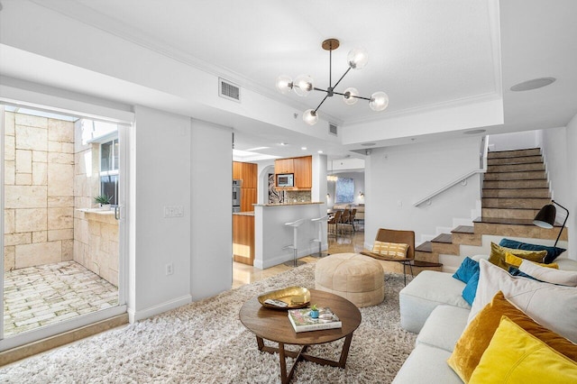 living room with crown molding, a tray ceiling, and a chandelier