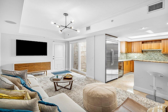 living room featuring a raised ceiling, crown molding, beverage cooler, and an inviting chandelier