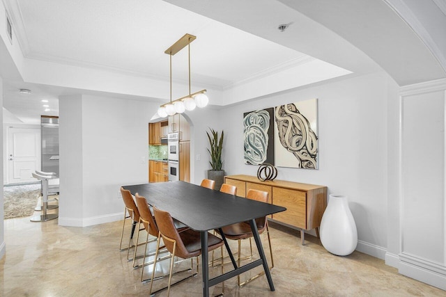 dining space featuring a tray ceiling and ornamental molding