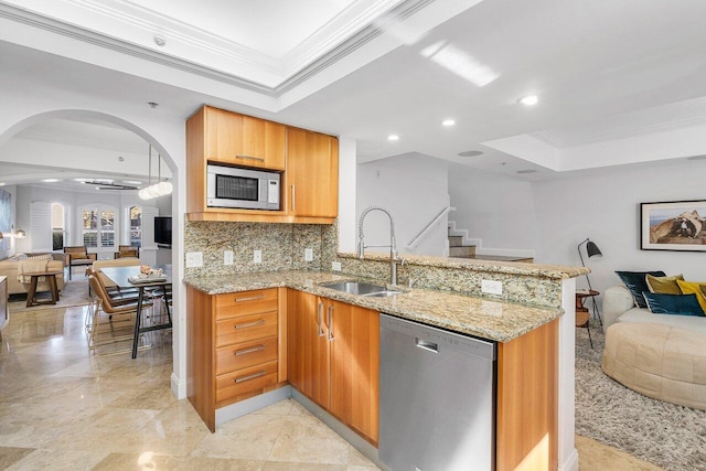 kitchen featuring light stone countertops, sink, ornamental molding, and stainless steel appliances