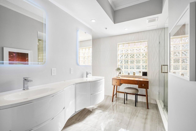 bathroom featuring vanity, a shower with door, and a wealth of natural light