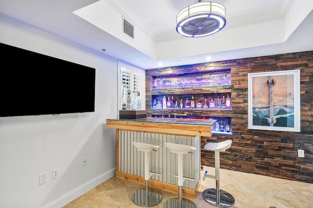 bar featuring tile patterned floors, ornamental molding, and wooden walls