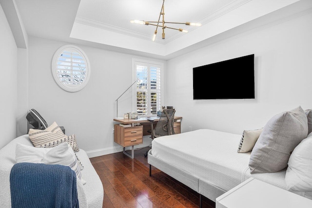 bedroom featuring a tray ceiling, dark wood-type flooring, a notable chandelier, and ornamental molding