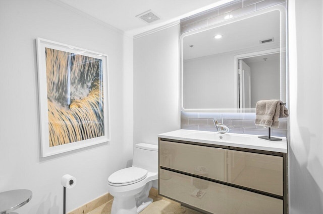 bathroom featuring tasteful backsplash, tile patterned floors, ornamental molding, vanity, and toilet