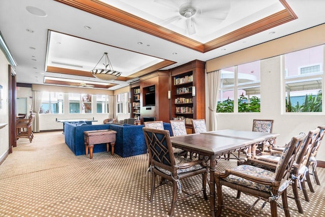 dining area featuring a tray ceiling, ceiling fan, carpet, and ornamental molding