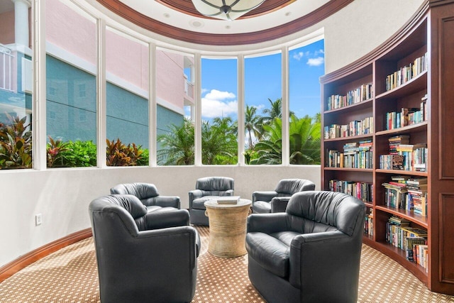 living area with a towering ceiling and ornamental molding