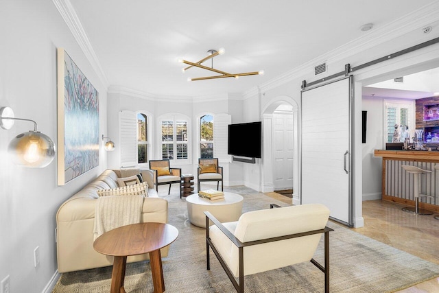 living room with a barn door, an inviting chandelier, and ornamental molding