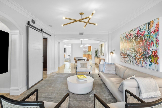 living room featuring a barn door, an inviting chandelier, and ornamental molding