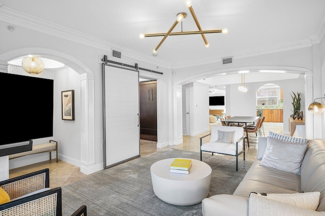 living room featuring a chandelier, a barn door, and ornamental molding