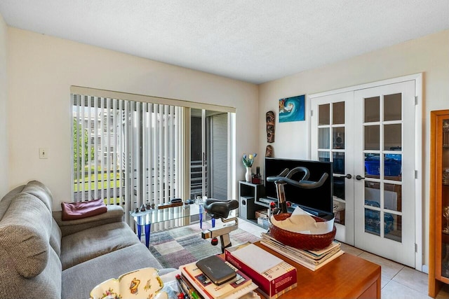 tiled living room with french doors and a textured ceiling