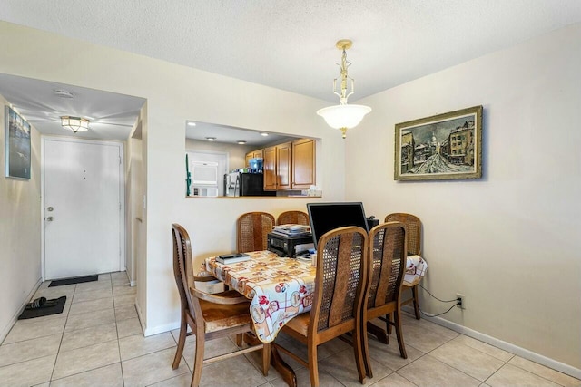 tiled dining space featuring a textured ceiling