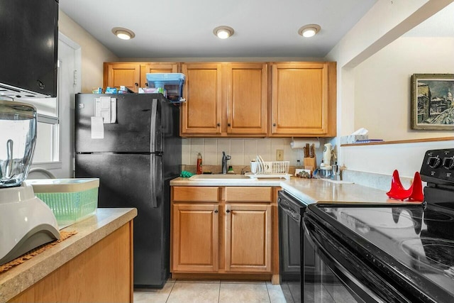 kitchen featuring light tile patterned flooring, sink, backsplash, and black appliances