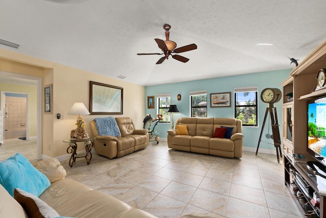 tiled living room with a textured ceiling, ceiling fan, and lofted ceiling