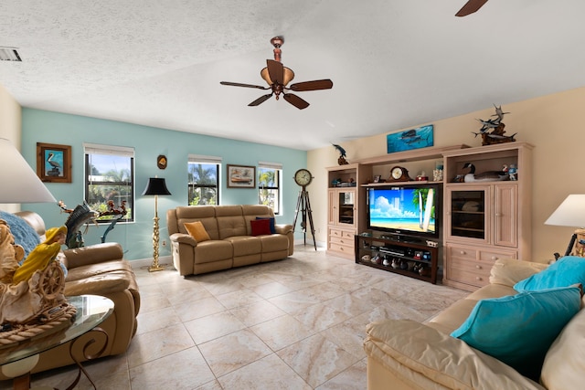 living room with a textured ceiling and ceiling fan