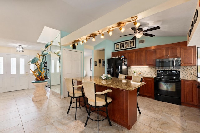 kitchen with light stone countertops, a breakfast bar, black appliances, a kitchen island, and lofted ceiling