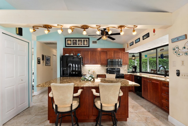 kitchen featuring a breakfast bar, ceiling fan, sink, black appliances, and a kitchen island