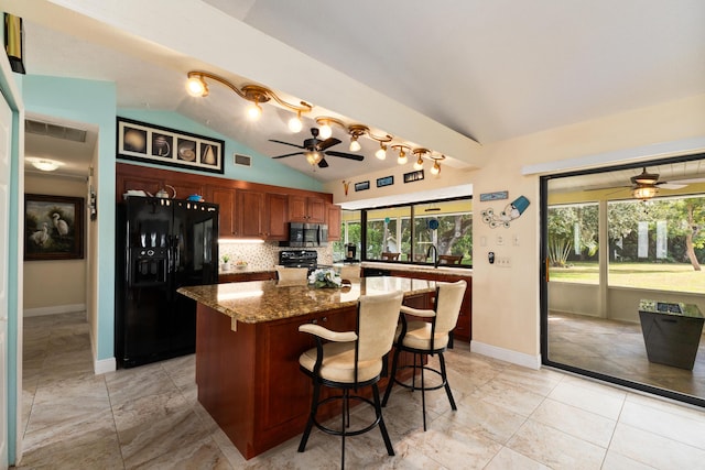 kitchen featuring a kitchen bar, a healthy amount of sunlight, black appliances, and lofted ceiling