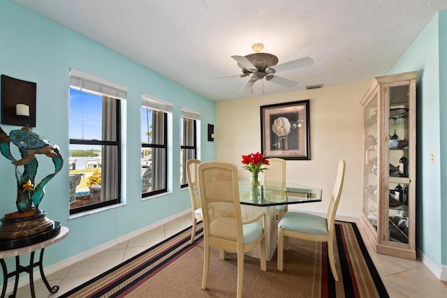 tiled dining space featuring ceiling fan and a textured ceiling