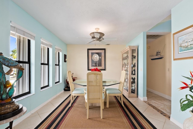 dining space featuring ceiling fan, light tile patterned floors, and a textured ceiling