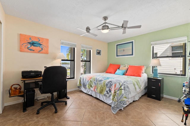 tiled bedroom featuring ceiling fan