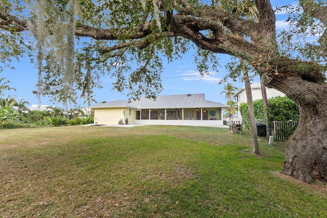 back of property featuring a lawn and a sunroom