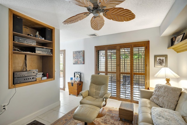 tiled living room featuring a textured ceiling and ceiling fan