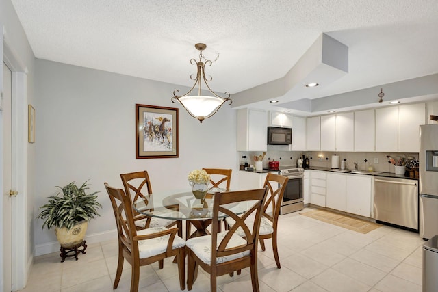 tiled dining space with a textured ceiling and sink