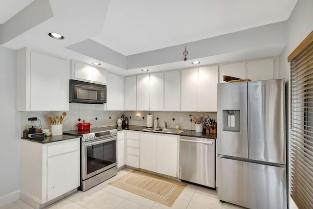 kitchen with decorative backsplash, sink, white cabinetry, and stainless steel appliances