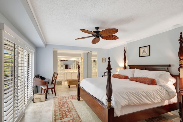 tiled bedroom with ensuite bath, ceiling fan, a textured ceiling, and ornamental molding