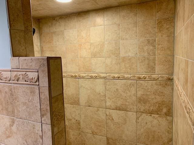 interior details featuring a tile shower