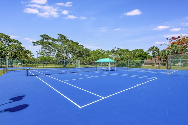 view of tennis court featuring basketball hoop