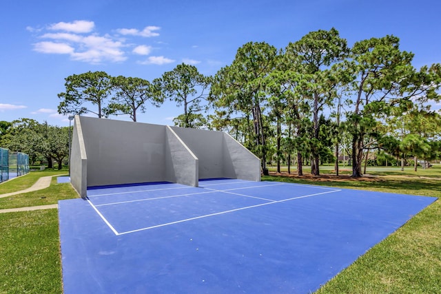 view of tennis court with a lawn