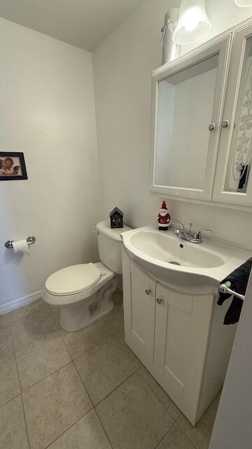 bathroom featuring tile patterned flooring, vanity, and toilet