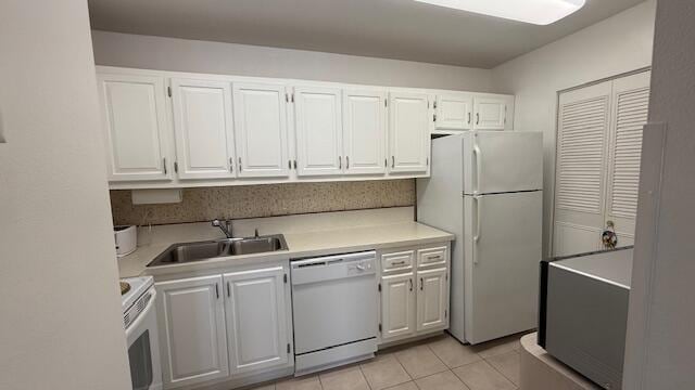 kitchen with white cabinetry, white appliances, sink, and light tile patterned floors