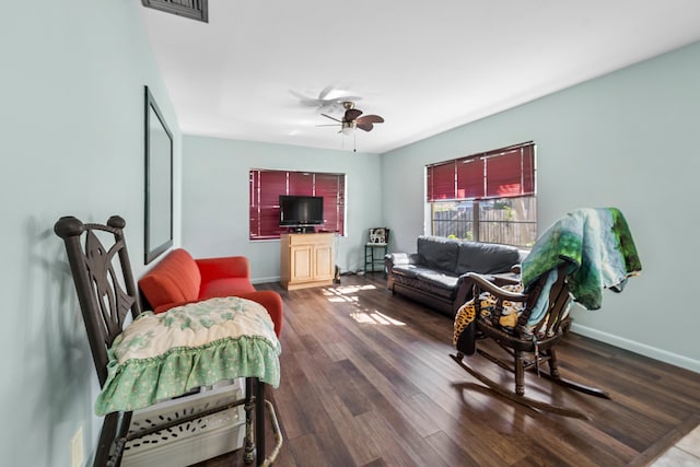 living room featuring dark hardwood / wood-style floors and ceiling fan