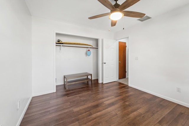 unfurnished bedroom featuring a closet, dark hardwood / wood-style floors, and ceiling fan