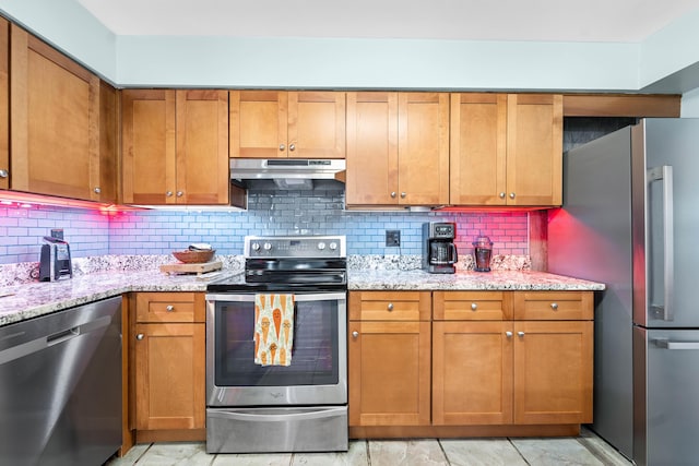 kitchen featuring backsplash, light stone counters, and stainless steel appliances