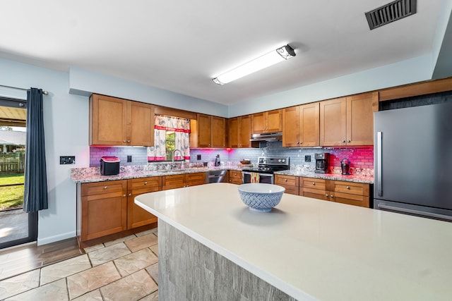 kitchen featuring light hardwood / wood-style flooring, sink, stainless steel appliances, and tasteful backsplash