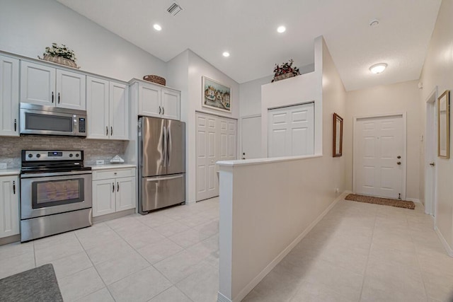 kitchen featuring appliances with stainless steel finishes, backsplash, high vaulted ceiling, and light tile patterned floors