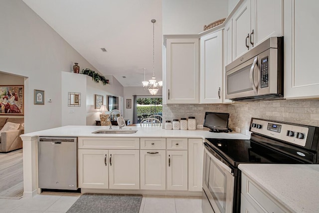 kitchen featuring sink, hanging light fixtures, stainless steel appliances, an inviting chandelier, and lofted ceiling