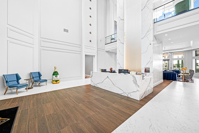 interior space featuring a towering ceiling and dark wood-type flooring