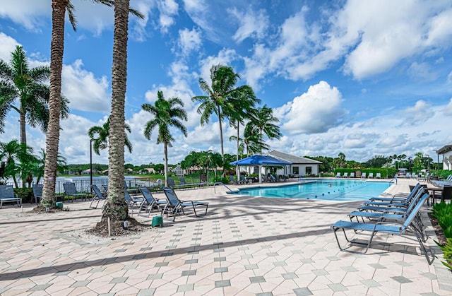 view of swimming pool with a patio area and a water view